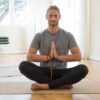 Serious man keeping hands together at yoga class