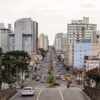 Trânsito em avenida movimentada no meio da semana simboliza vida em Curitiba