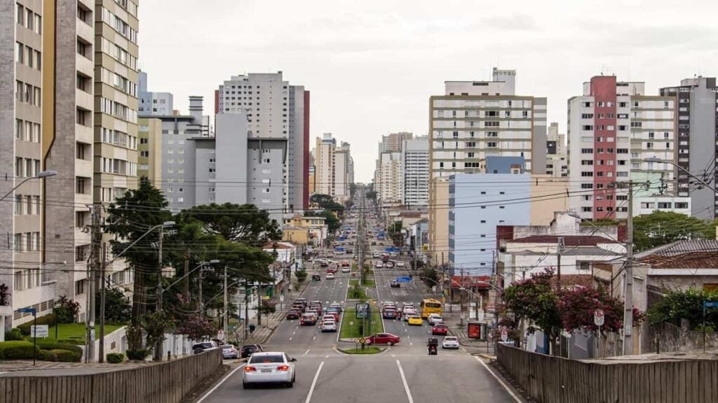 Trânsito em avenida movimentada no meio da semana simboliza vida em Curitiba